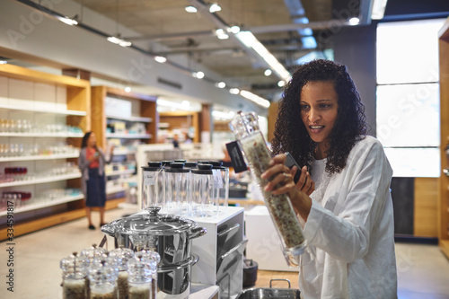 Woman shopping for pepper grinder in home goods store