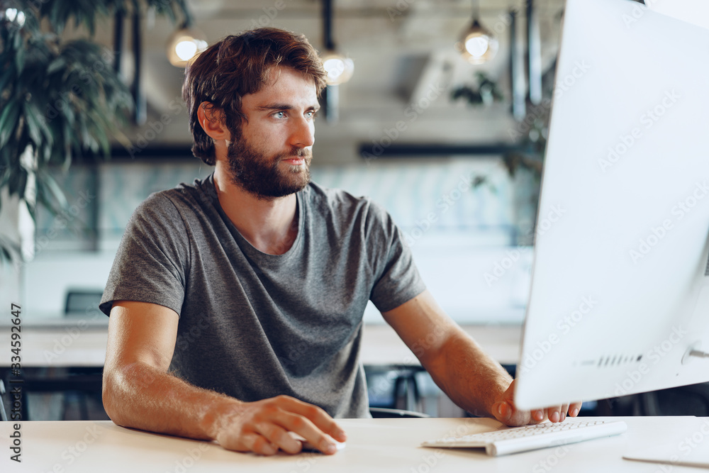 Bearded man freelancer using computer in a modern coworking place. Freelance business concept Bearded man freelancer using computer in a modern coworking place. Freelance business concept