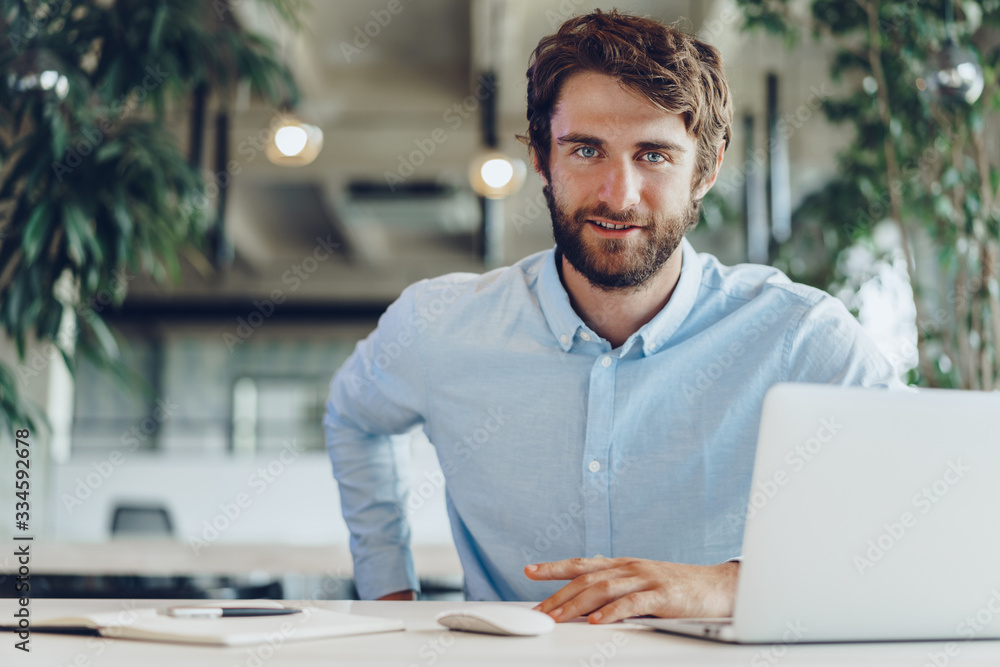 Businessman in shirt working on his laptop in an office. Open space office Businessman in shirt working on his laptop in an office. Open space office