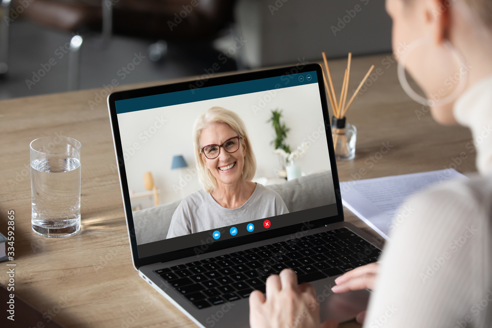Back view of woman speak talk on video call on computer with smiling  elderly mother, young female communicate online using laptop Webcam chat  with happy mature mom, quarantine at home Stock Photo