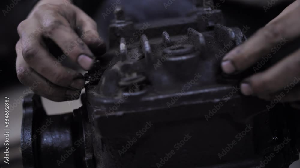 Man hands wring bolts into the gearbox cover. Hands in oil and dirty Man hands wring bolts into the gearbox cover. Hands in oil and dirty