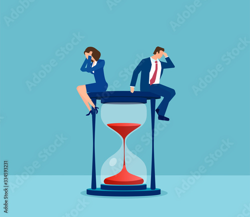 Vector of a stressed business man and business woman sitting on a hourglass