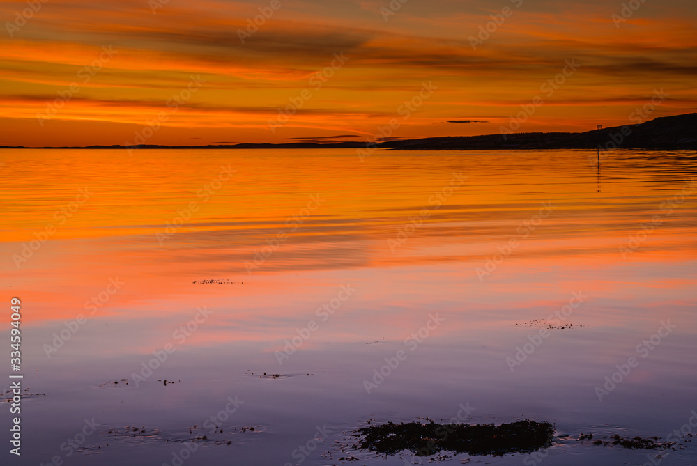 Naklejka premium Złota godzina nad skalistym wybrzeżem podczas zachodu słońca w Parku Narodowym Ytre Hvaler w Norwegii