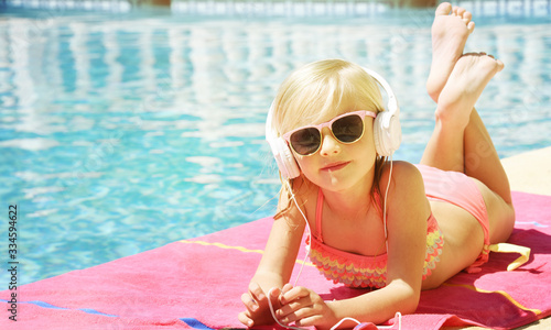 Children blond girl in swimming pool. Summer vacations.