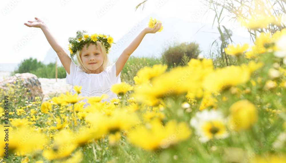 Children blond girl with daisy flowers. Summer vacation time.