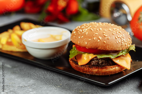 burger with cutlet  cheese and tomatoes. With french fries and burger sauce