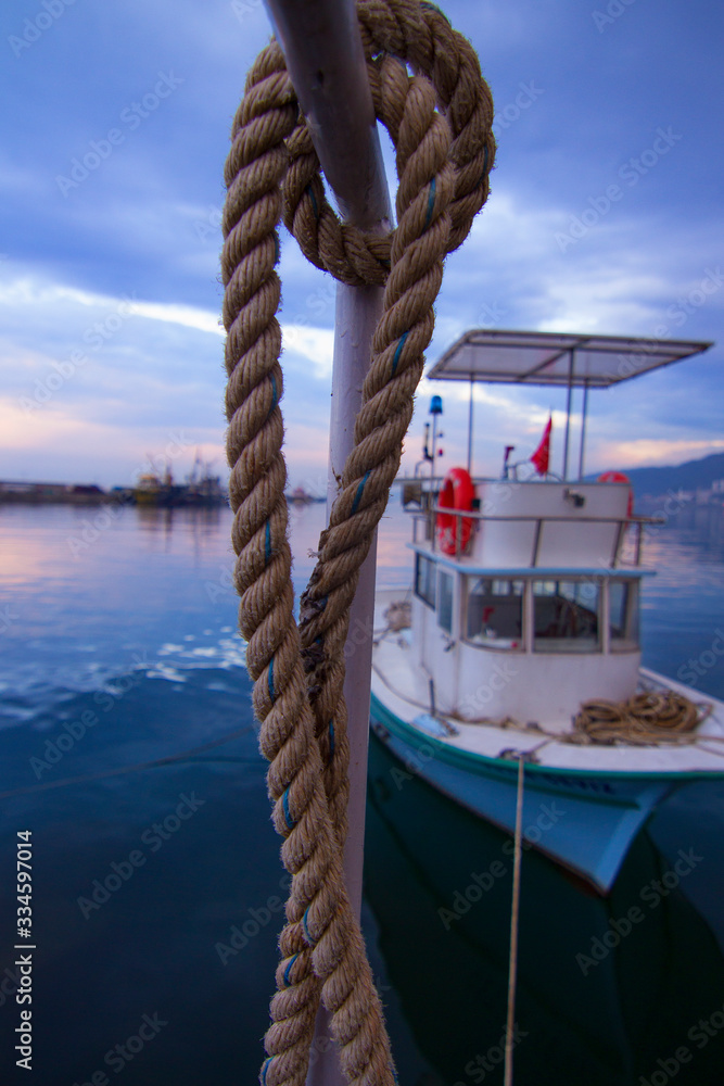 Obraz premium cute fishing boat and rope in the harbor