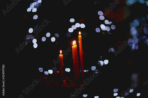 burning candles on a black background with blue lights photo