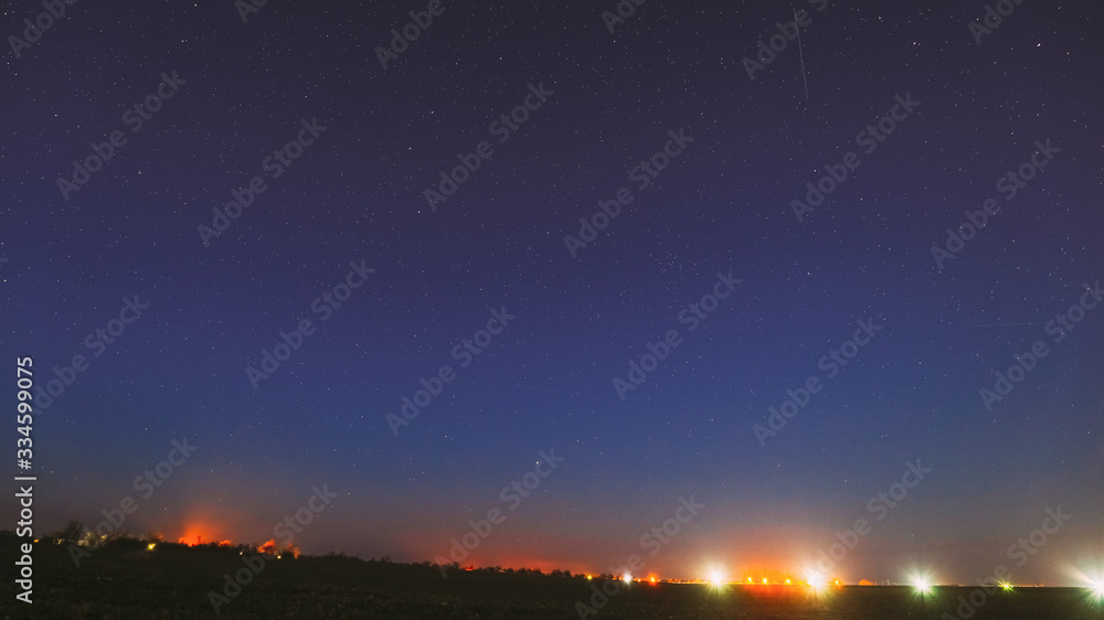 Night Starry Sky With Glowing Stars Above Landscape With Town City Lights. Night Starry Sky Above Ground. Copy Space