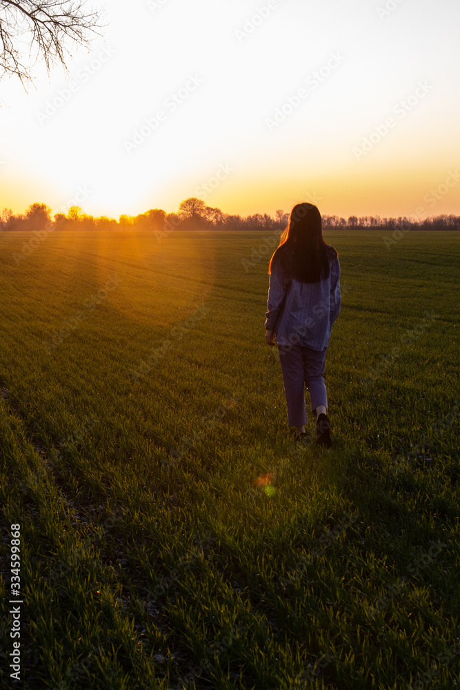  girl walks in the sunset field