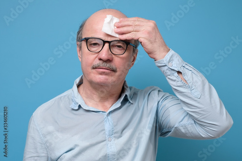 Sweaty senior man suffering from heat stroke or high temperature