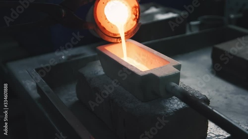 Hot and liquid precious metal is poured in a mold on a jewelry production