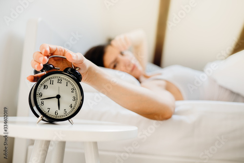 Alarm clock ringing.Woman waking up in early morning for work.Sleeping disorder.Tired woman oversleeping,bad sleep quality.Sleep deprived mom.Waking inertia,bad mood after dreaming nightmares.Insomnia