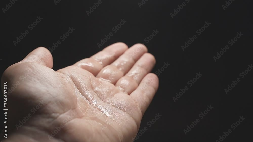 Slow motion. Close-up of a man's hand splashing disinfectant on the palm and rubbing, prevention of the spread of the coronavirus pandemic, covid-19. Slow motion. Close-up of a man's hand splashing disinfectant on the palm and rubbing, prevention of the spread of the coronavirus pandemic, covid-19.