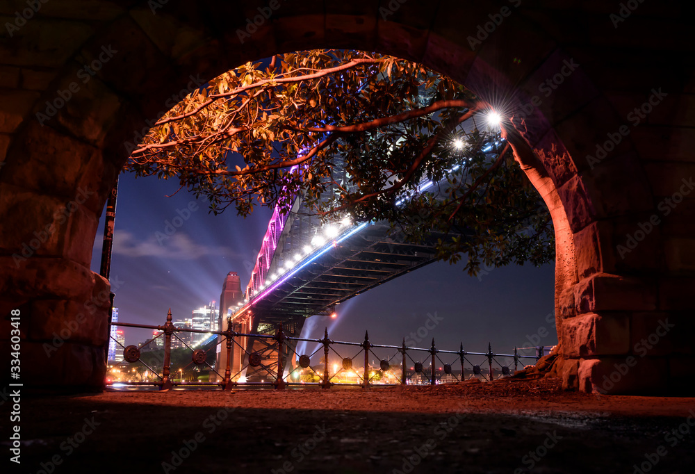 Fotografie View of The Sydney Harbour Bridge from behind a stone arch, Sydney Australia