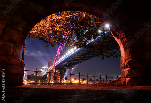Photography View of The Sydney Harbour Bridge from behind a stone arch, Sydney Australia