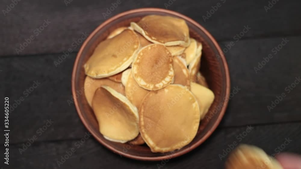 Pancakes in ceramic bowl on oak table Pancakes in ceramic bowl on oak table