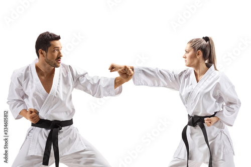 Karate man and woman with black belts fighting