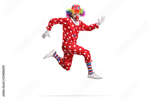 Clown in a polka dot red costume jumping