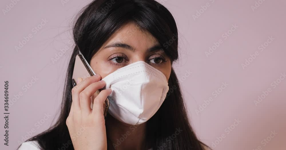 Pandemic Covid-19 coronavirus protection. Portrait of a brunette woman wearing protective mask speaking by cellphone .Concept of health and safety life, , virus protection. close up view Pandemic Covid-19 coronavirus protection. Portrait of a brunette woman wearing protective mask speaking by cellphone .Concept of health and safety life, , virus protection. close up view