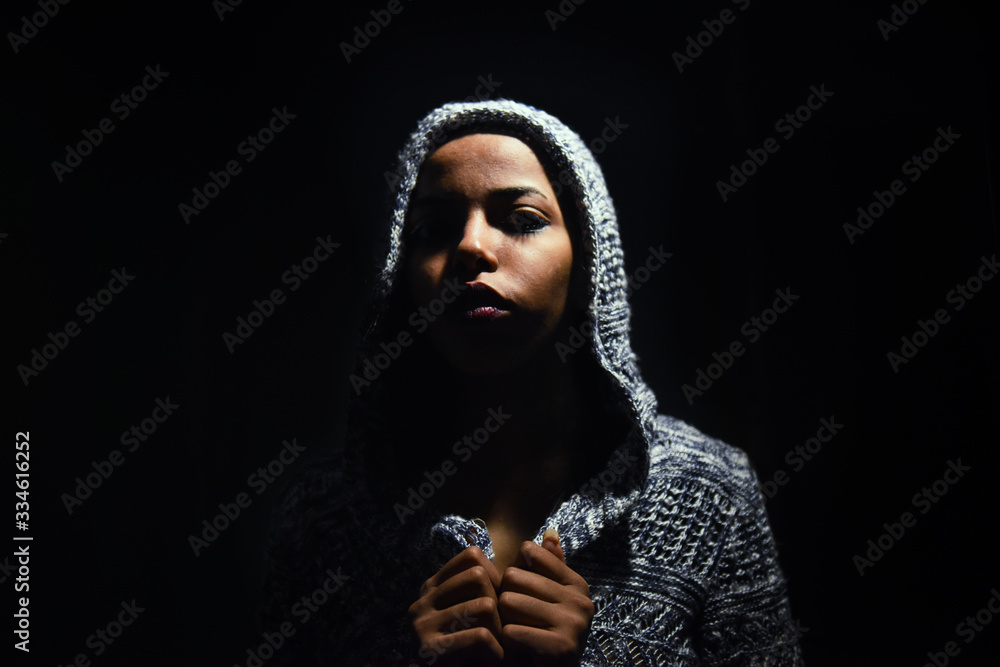 Close up Studio portrait of beautiful young african woman , Low key face shot of elegant girl looking at camera against dark background.
