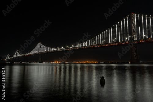 Natural San Francisco Bay Bridge with Oakland in background and water reflection night photo. Bay Area  California. 
