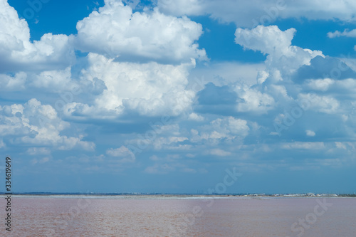 White clouds over the pink salt lake