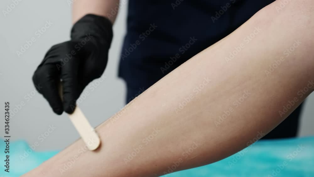 Young woman receives laser hair removal for legs at beauty salon Young woman receives laser hair removal for legs at beauty salon