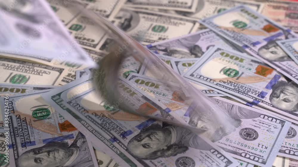 Girl counts and lays out dollar bills on a red table. Close-up of hands with dollar bills Girl counts and lays out dollar bills on a red table. Close-up of hands with dollar bills