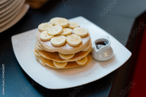pancakes breakfast with bananas on white dish