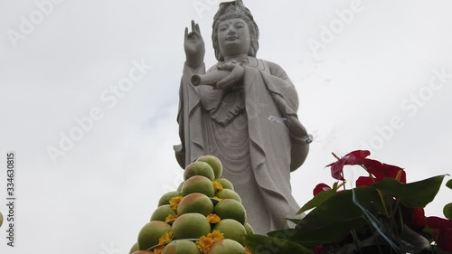 Incense smoke billows in front of Lady Buddha statue at Chua Bat Nha temple in Santa Ana California photo