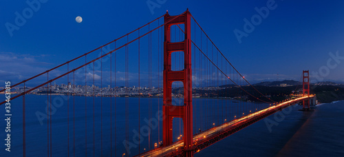 Panorama of Golden Gate Bridge and San Francisco skyline at twilight with rising moon