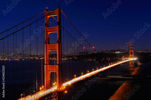 Golden Gate Bridge and San Francisco skyline at night with passing ocean cargo ship