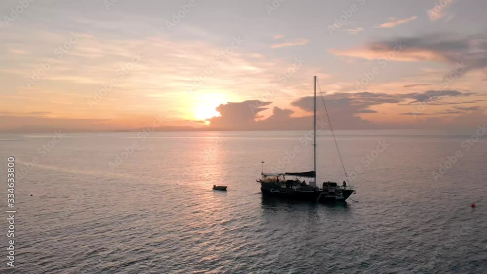 Luxury Wood Sailing Boat at Sea at Sunrise. 4K Drone (Close Orbit Shot). Luxury Wood Sailing Boat at Sea at Sunrise. 4K Drone (Close Orbit Shot).