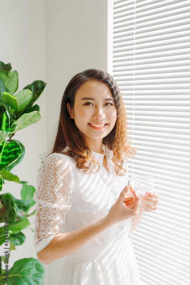 Beautiful asian women healthy diet eating vitamin pill with water Beautiful asian women healthy diet eating vitamin pill with water