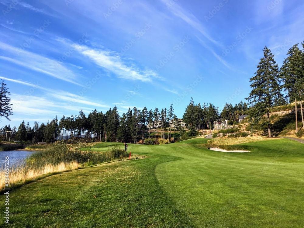 A beautiful par 4  at a golf course surrounded by water and forests and beautiful scenery outside of Victoria, British Columbia, Canada.