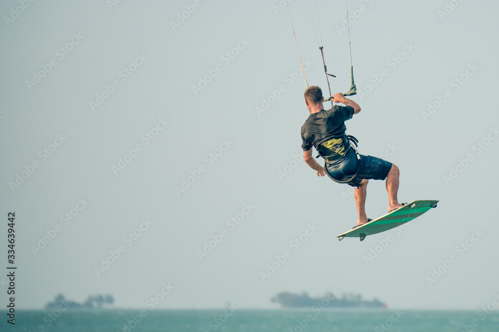 Kiteboarder or kite surfer. Man performing kitesurfing kiteboarding tricks. Kiteboarder or kite surfer. Man performing kitesurfing kiteboarding tricks.