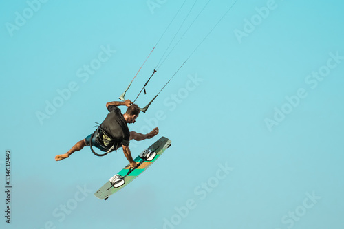 Kiteboarder or kitesurfer athlete performing kitesurfing kiteboarding tricks.