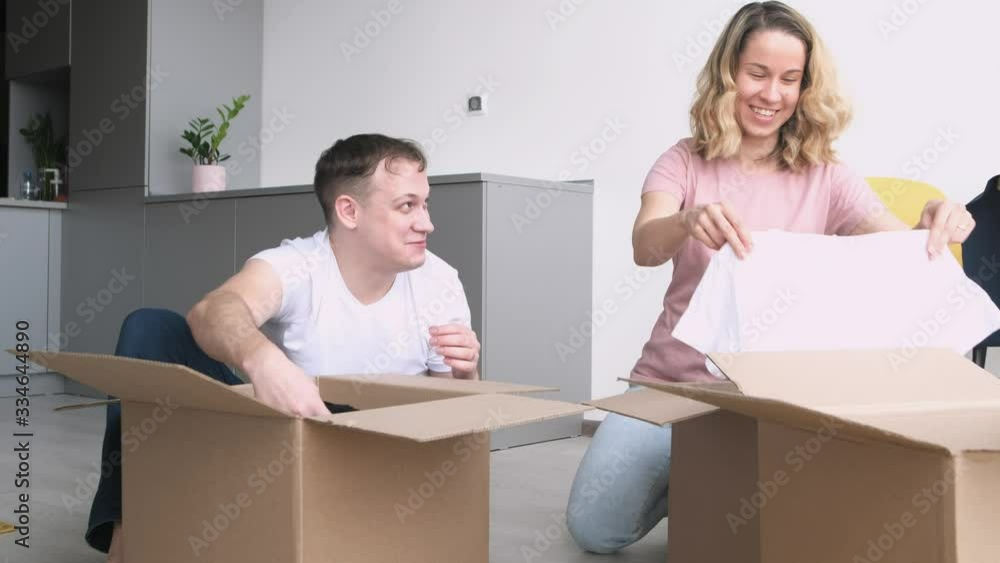 Happy couple is having fun with cardboard boxes in new house at moving day. Happy couple is having fun with cardboard boxes in new house at moving day.