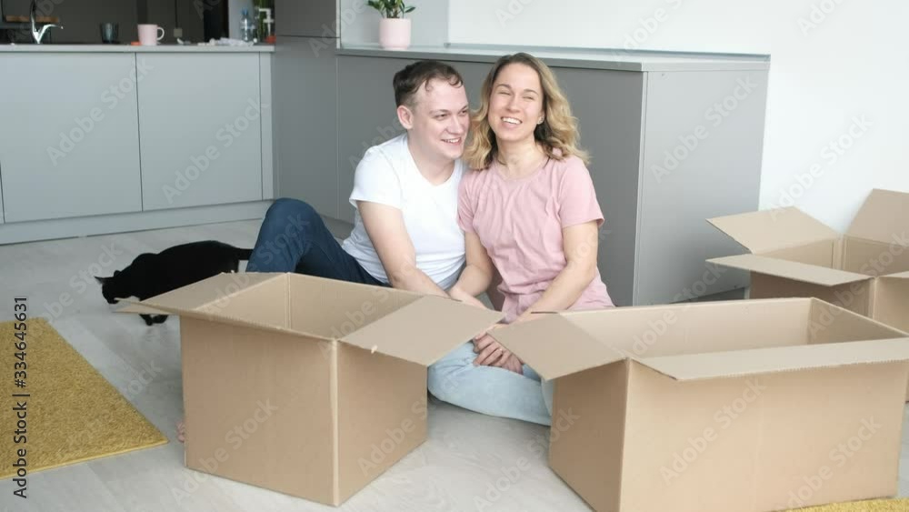 moving, home and couple concept - smiling couple relaxing on the floor in new home moving, home and couple concept - smiling couple relaxing on the floor in new home