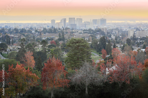 Sunset views of Oakland Downtown and San Francisco Bay from a hilltop in Mountain View Cemetery. Oakland, Alameda County, California, USA.