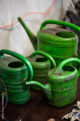 dirty old green watering cans in auto mechanics garage