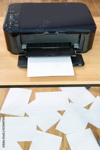 사무실 책상 위에 프린터와 a4용지 컴퓨터