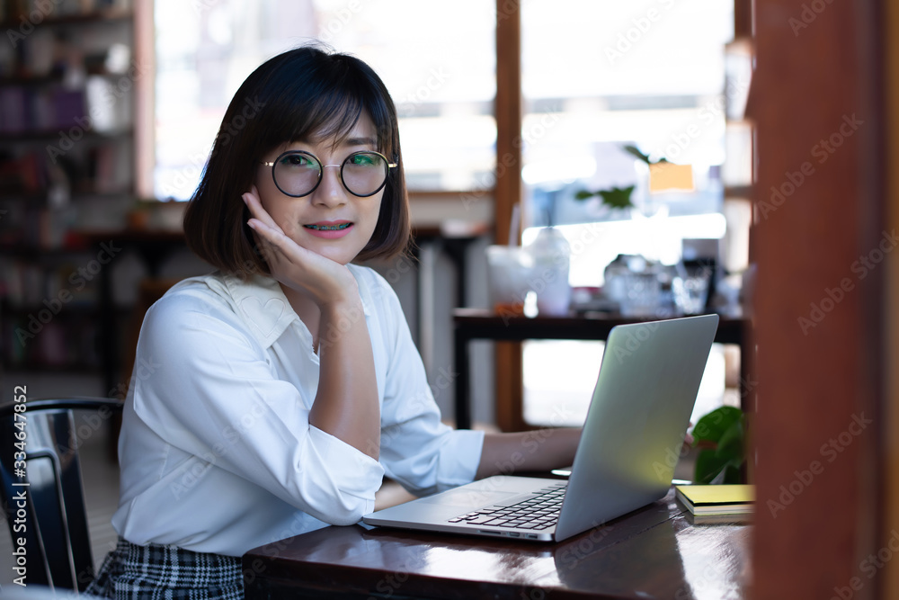 A beautiful Asian businessman wearing a white shirt Working with a laptop computer at a coffee shop A beautiful Asian businessman wearing a white shirt Working with a laptop computer at a coffee shop