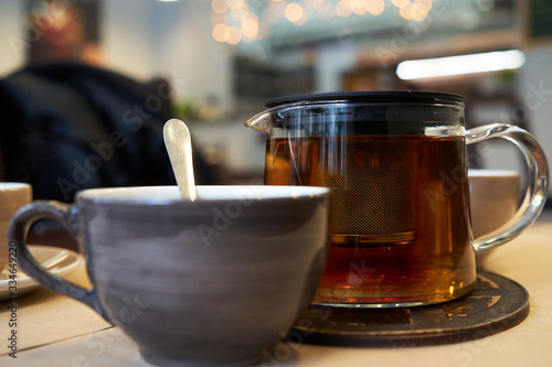 Cup and teapot on a table in a cafe.