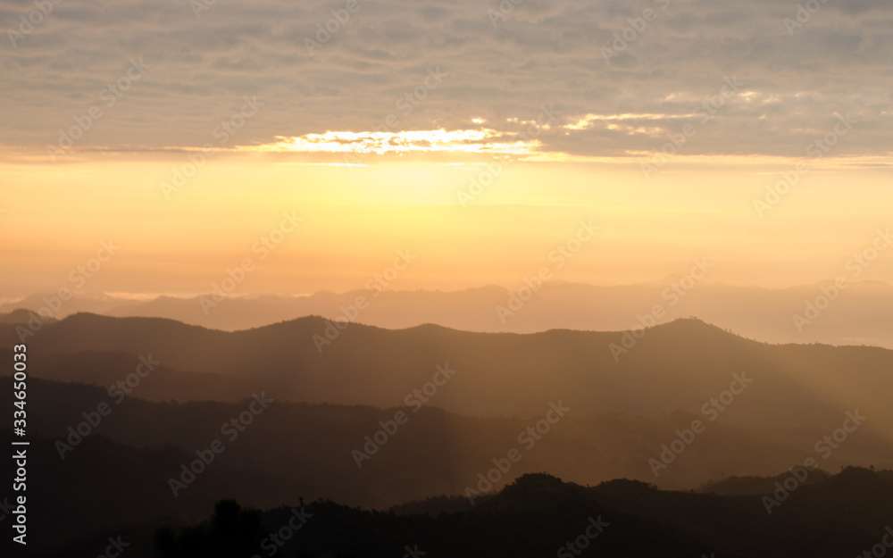 Layer of mountains and mist with ray of sunset Layer of mountains and mist with ray of sunset