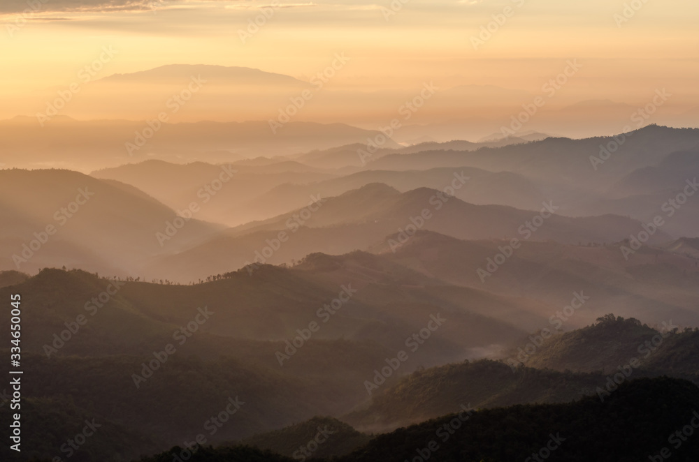 Layer of mountains and mist with ray of sunset