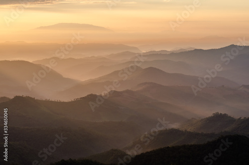 Layer of mountains and mist with ray of sunset