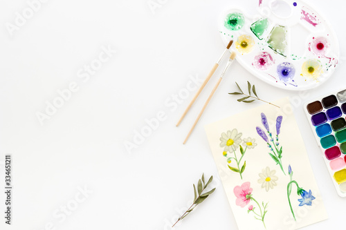 Watercolor painting. Picture with flowers, paints, palette on white background top-down copy space