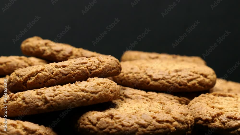 Rotating Close Up Of Fresh Brown Oatmeal Cookies On A Black Plate On A Black Background. Rotating Close Up Of Fresh Brown Oatmeal Cookies On A Black Plate On A Black Background.